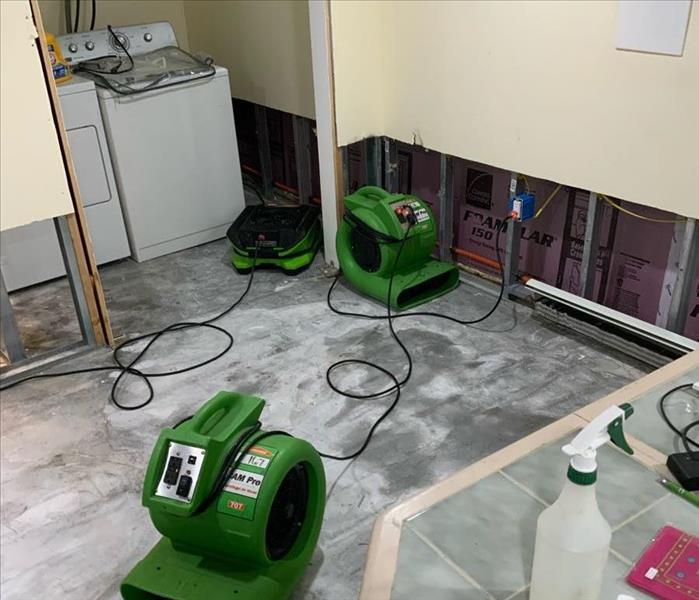 Room with SERVPRO drying equipment on slab substrate by flood cut walls