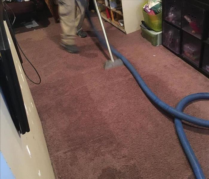 SERVPRO technicians with extraction equipment on a wet carpet