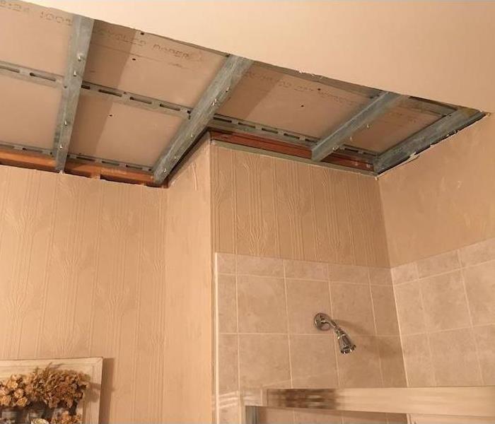 Bathroom with ceiling studs exposed over shower