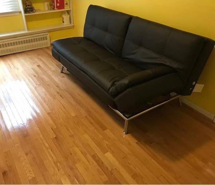 Futon sofa in room with wood floor