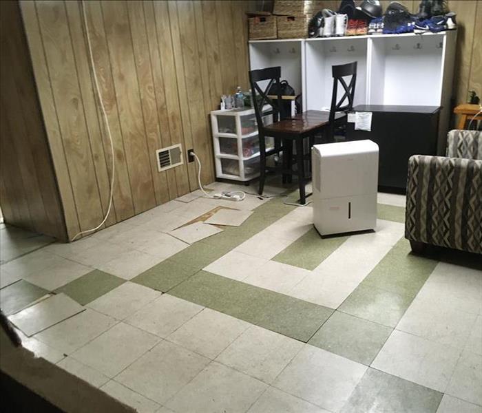 Floor with loose tiles and SERVPRO equipment