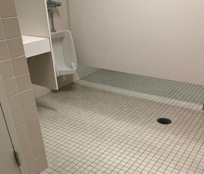 Bathroom with white tile and drain in the floor