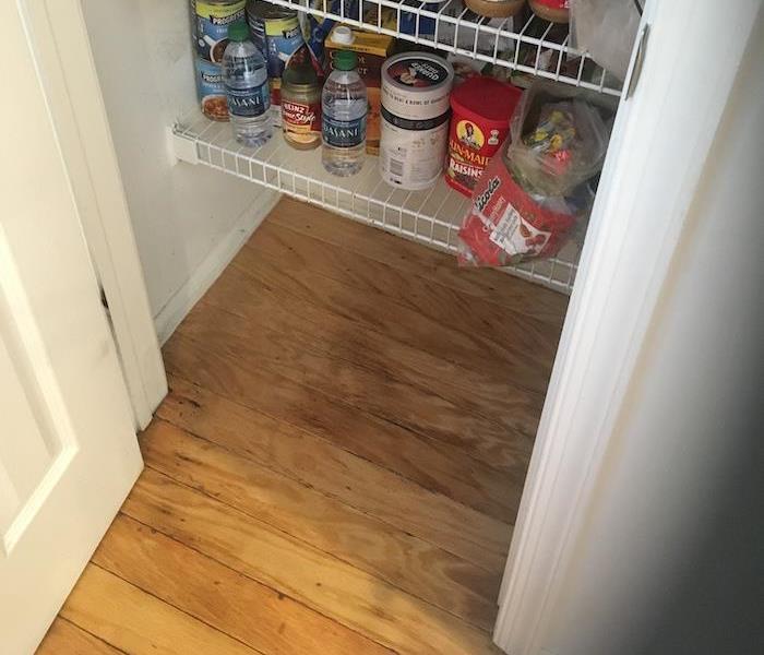 pantry with items and wet wood floorboards