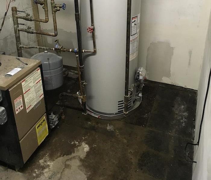 Wet basement floors with water damage from water heater 