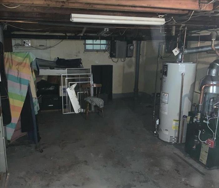 Basement with items stored in boxes and a furnace and water heater