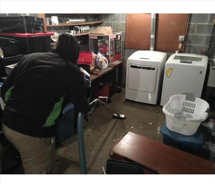 SERVPRO employee extraction water from basement laundry room