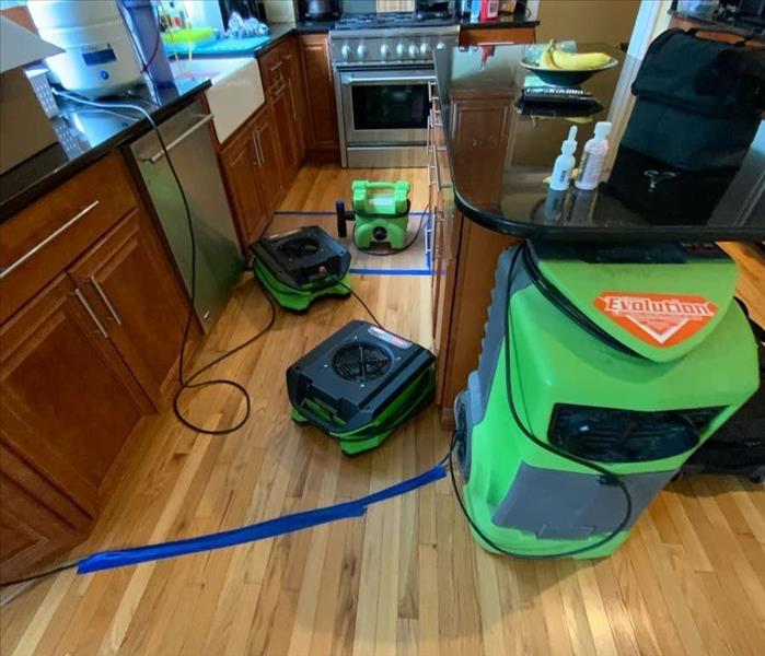 SERVPRO drying equipment in a kitchen on a hardwood floor